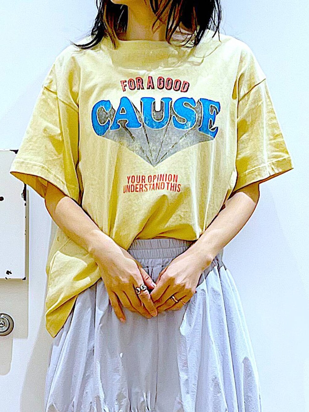 ブルー系のスカート、ホワイト系のパンプス、ベージュ系のショルダーバッグを着用したレディースの春コーディネートの7枚目の写真