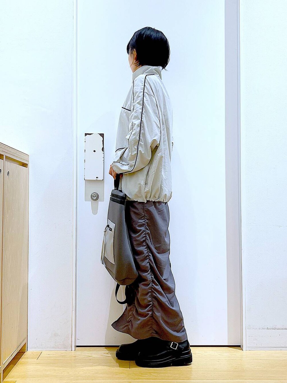 ブラック系のブーツ、グレー系のバックパック/リュック、グレー系のブルゾンを着用したレディースの秋コーディネートの3枚目の写真