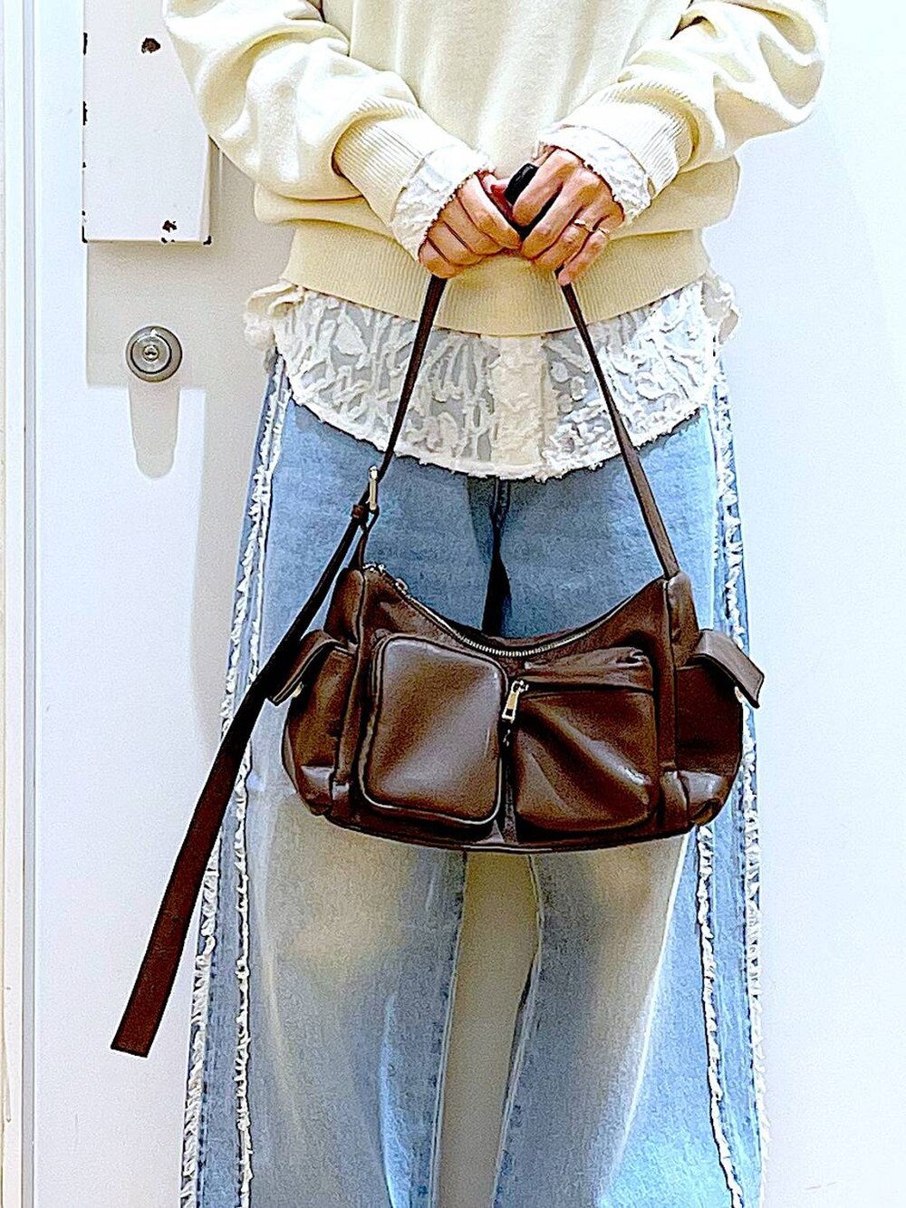 シルバー系のローファー、ブラウン系のショルダーバッグ、ホワイト系のニット/セーターを着用したレディースの春コーディネートの9枚目の写真