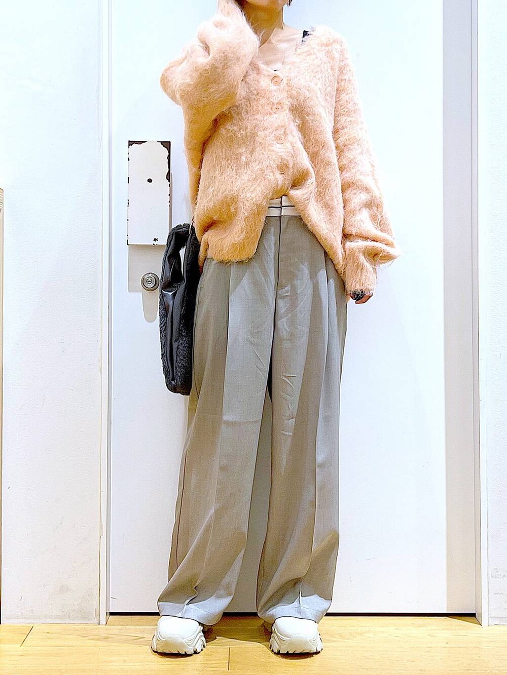 ピンク系のカーディガン/ボレロ、グレー系のショルダーバッグ、ベージュ系のブーツを着用したレディースの冬コーディネートの6枚目の写真