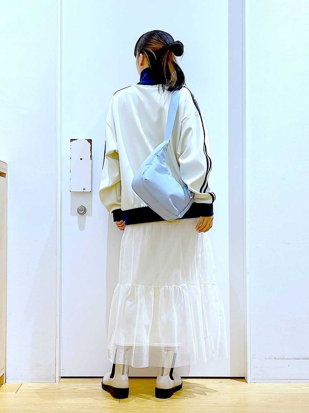 ベージュ系のブーツ、ブルー系のショルダーバッグ、ベージュ系のスウェットを着用したレディースの春コーディネートの5枚目の写真