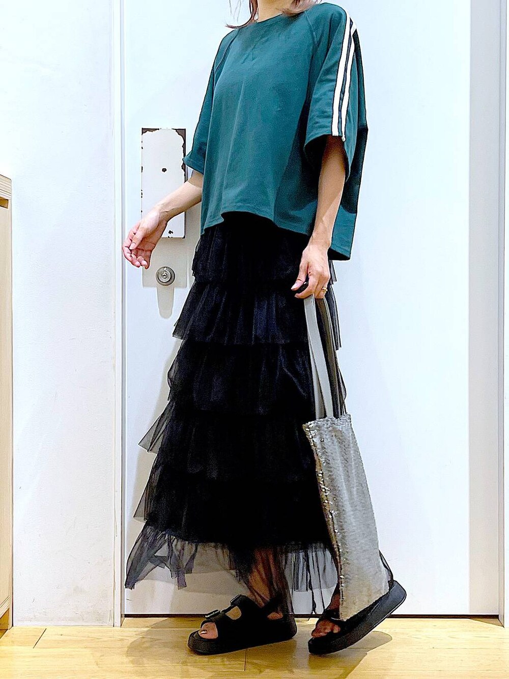 ブラック系のサンダル、シルバー系のトートバッグ、ブラック系のスカートを着用したレディースの夏コーディネートの6枚目の写真