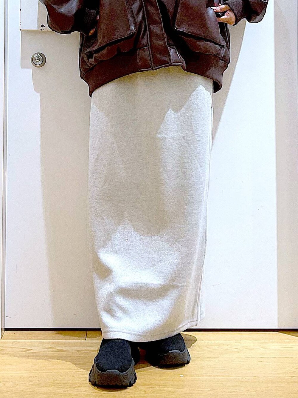 ブラウン系のブルゾン、ブラック系のブーツ、ブラック系のショルダーバッグを着用したレディースの冬コーディネートの8枚目の写真