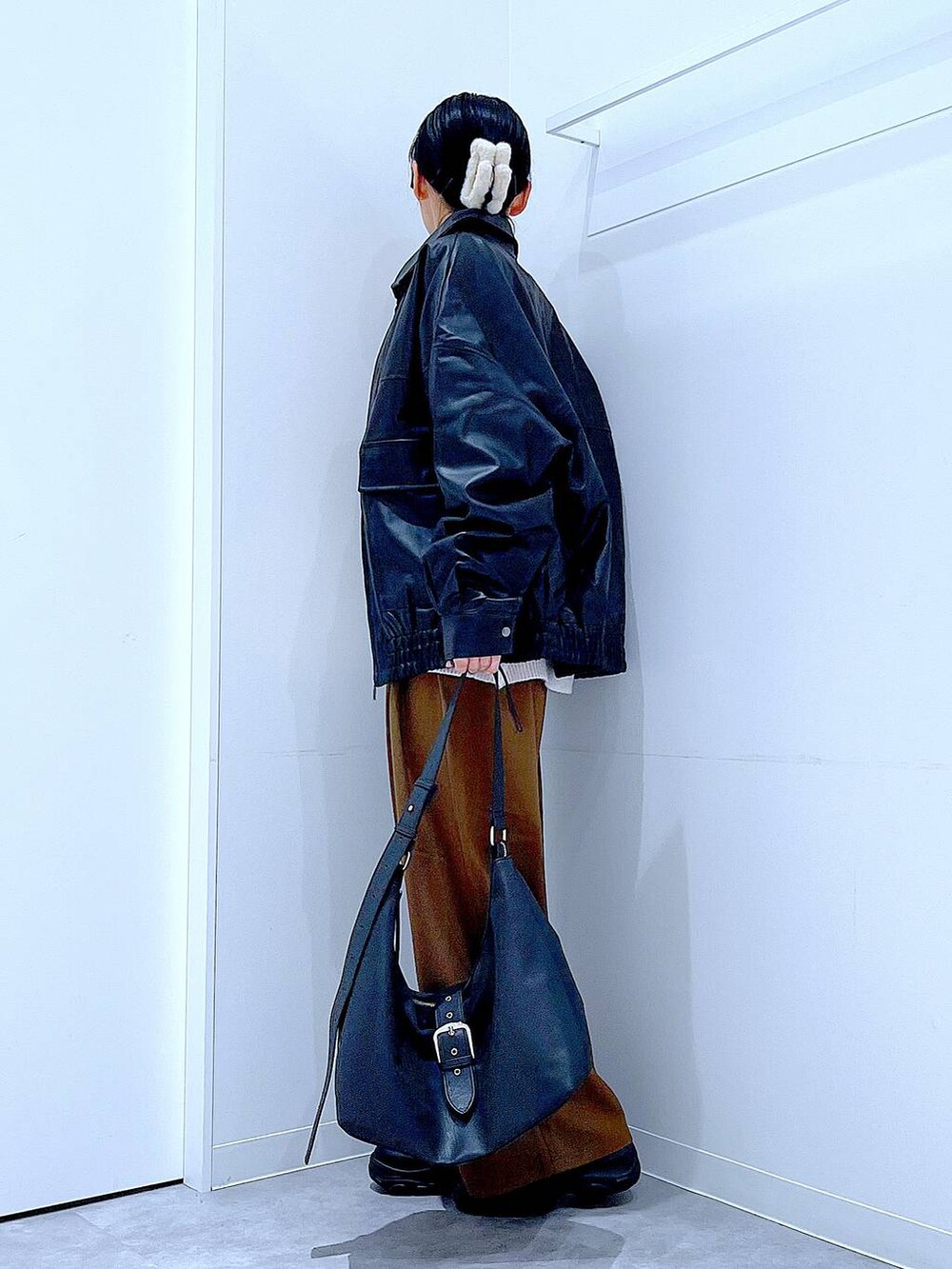 ブラック系のブルゾン、ブラック系のブーツ、ベージュ系のニット/セーターを着用したレディースの秋コーディネートの3枚目の写真