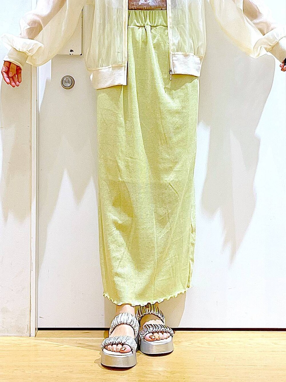 グリーン系のスカート、シルバー系のサンダル、シルバー系のトートバッグを着用したレディースの夏コーディネートの8枚目の写真