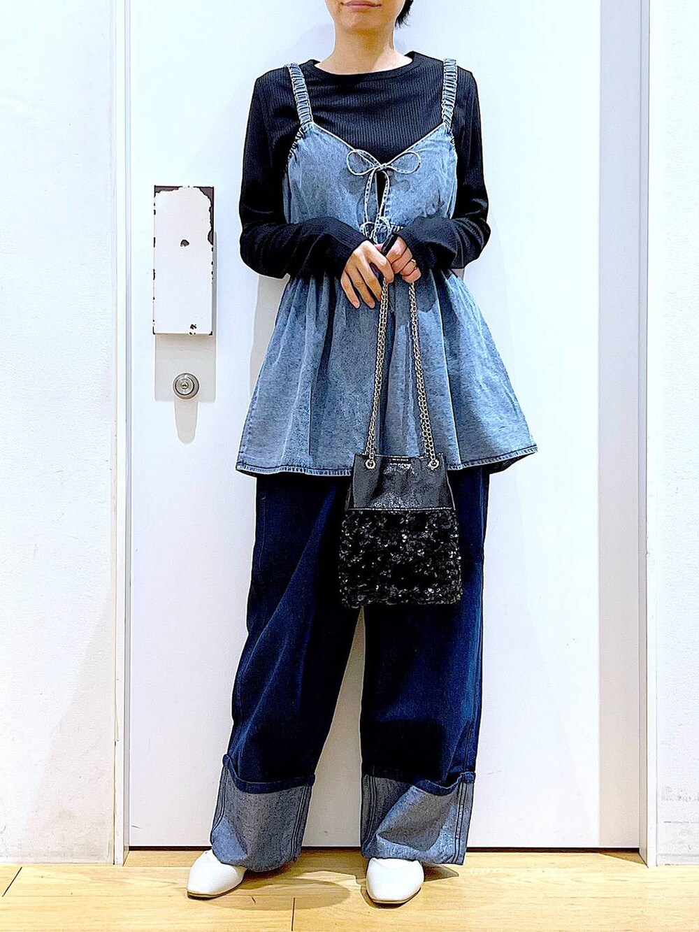 ホワイト系のパンプス、ブルー系のデニムパンツ、ブラック系のショルダーバッグを着用したレディースの春コーディネートの6枚目の写真