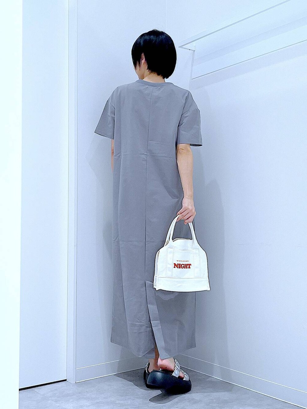 シルバー系のサンダル、グレー系のワンピース、ホワイト系のトートバッグを着用したレディースの夏コーディネートの5枚目の写真