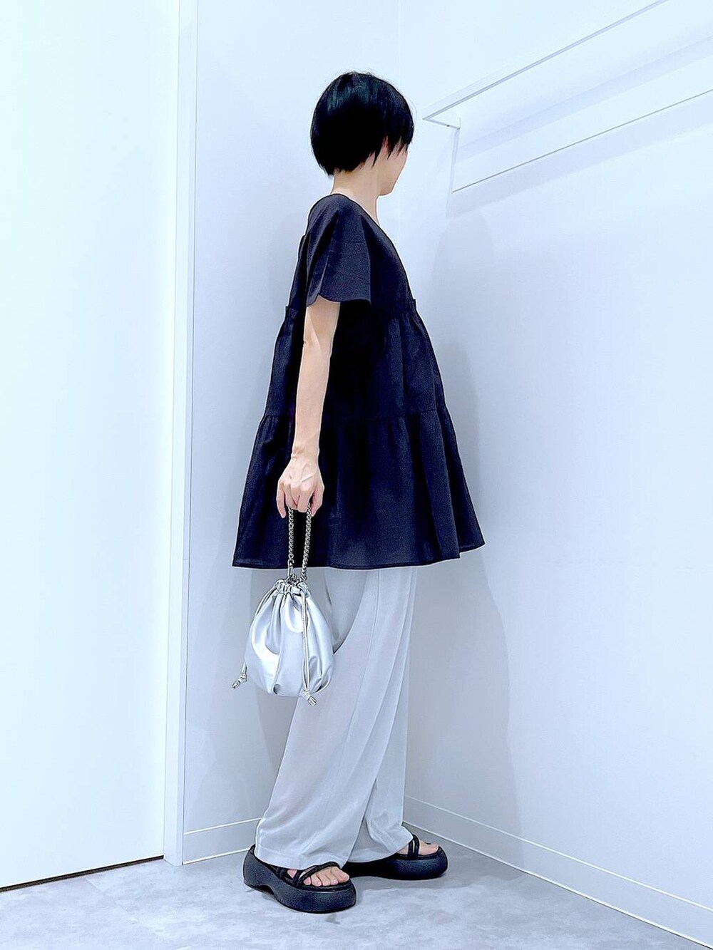 シルバー系のショルダーバッグ、ブラック系のサンダル、グレー系のその他パンツを着用したレディースの夏コーディネートの3枚目の写真