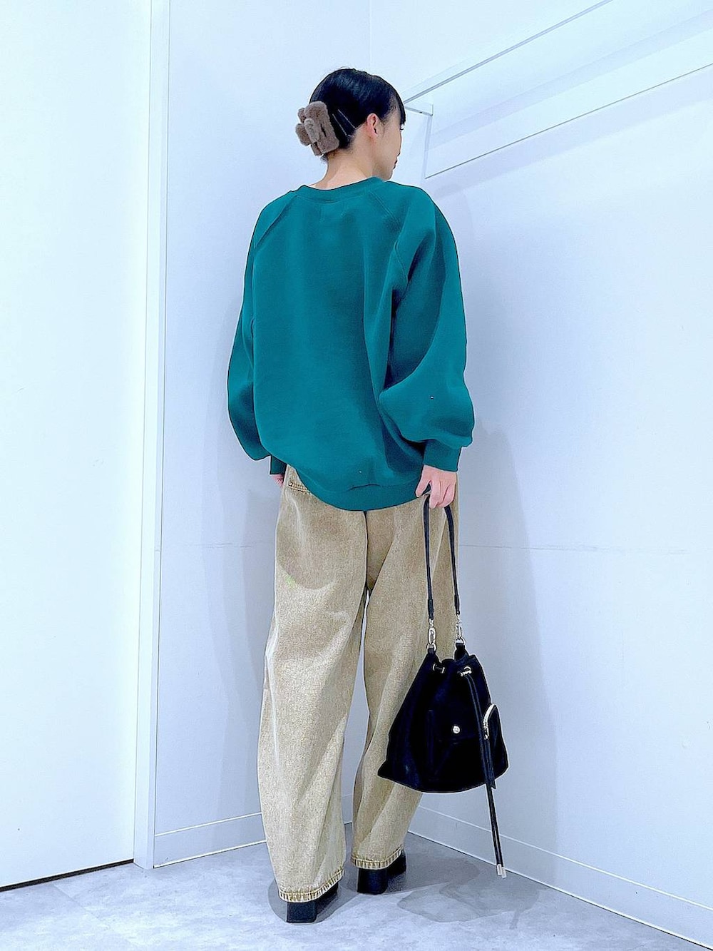 ベージュ系のデニムパンツ、ブラック系のショルダーバッグ、ブラック系のブーツを着用したレディースの冬コーディネートの5枚目の写真