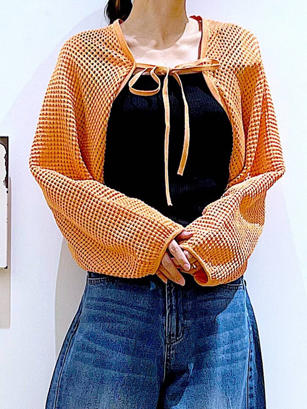 ブルー系のデニムパンツ、オレンジ系のカーディガン/ボレロ、その他のパンプスを着用したレディースの春コーディネートの7枚目の写真