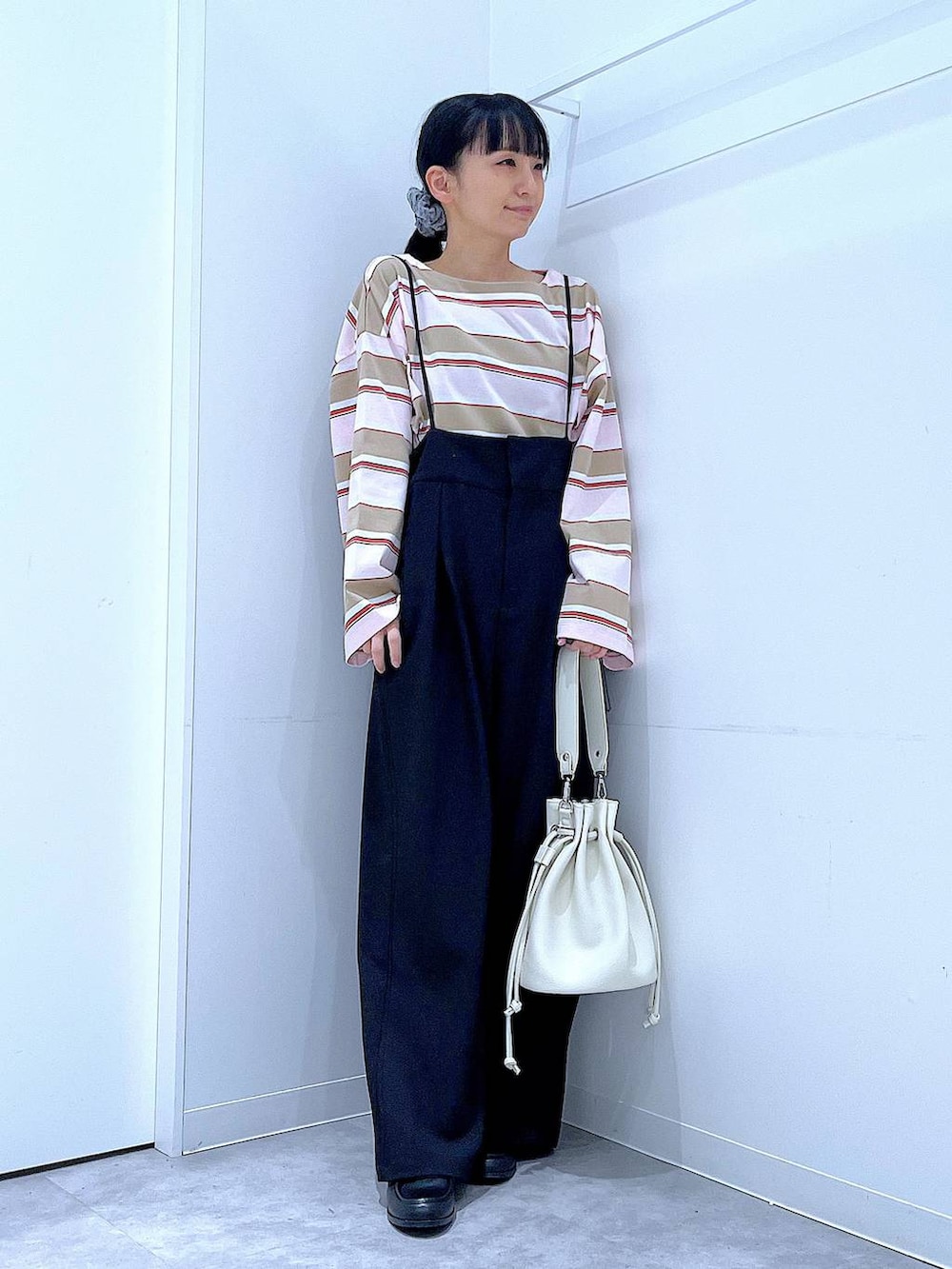 ブラック系のローファー、ホワイト系のショルダーバッグ、ブラック系のサロペット/オーバーオールを着用したレディースの春コーディネートの2枚目の写真