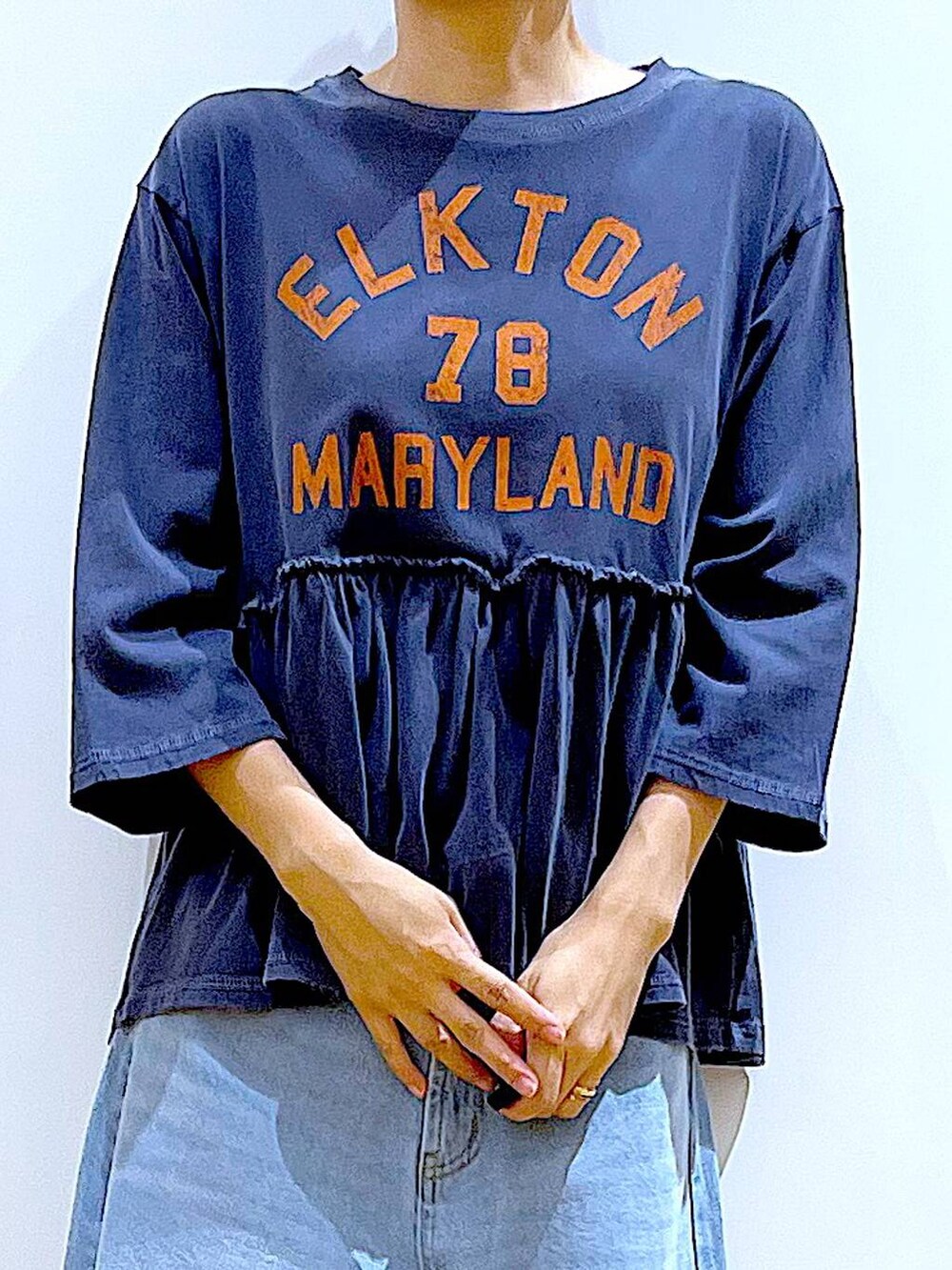 ブラック系のショルダーバッグ、ブルー系のデニムパンツ、シルバー系のパンプスを着用したレディースの秋コーディネートの7枚目の写真