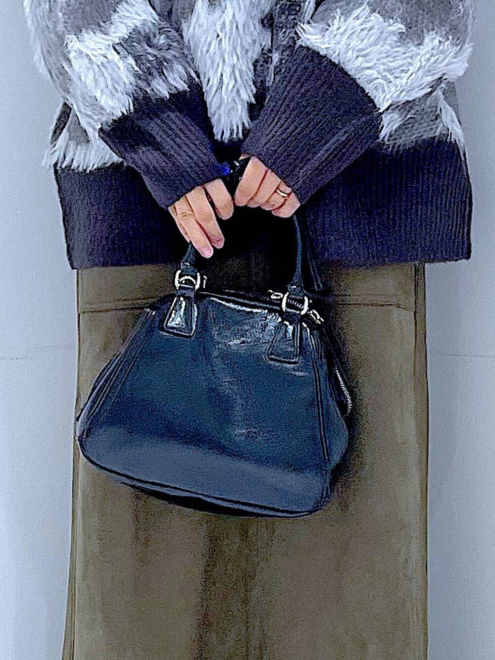 ブラック系のブーツ、ブラック系のニット/セーター、ブラック系のショルダーバッグを着用したレディースの冬コーディネートの9枚目の写真