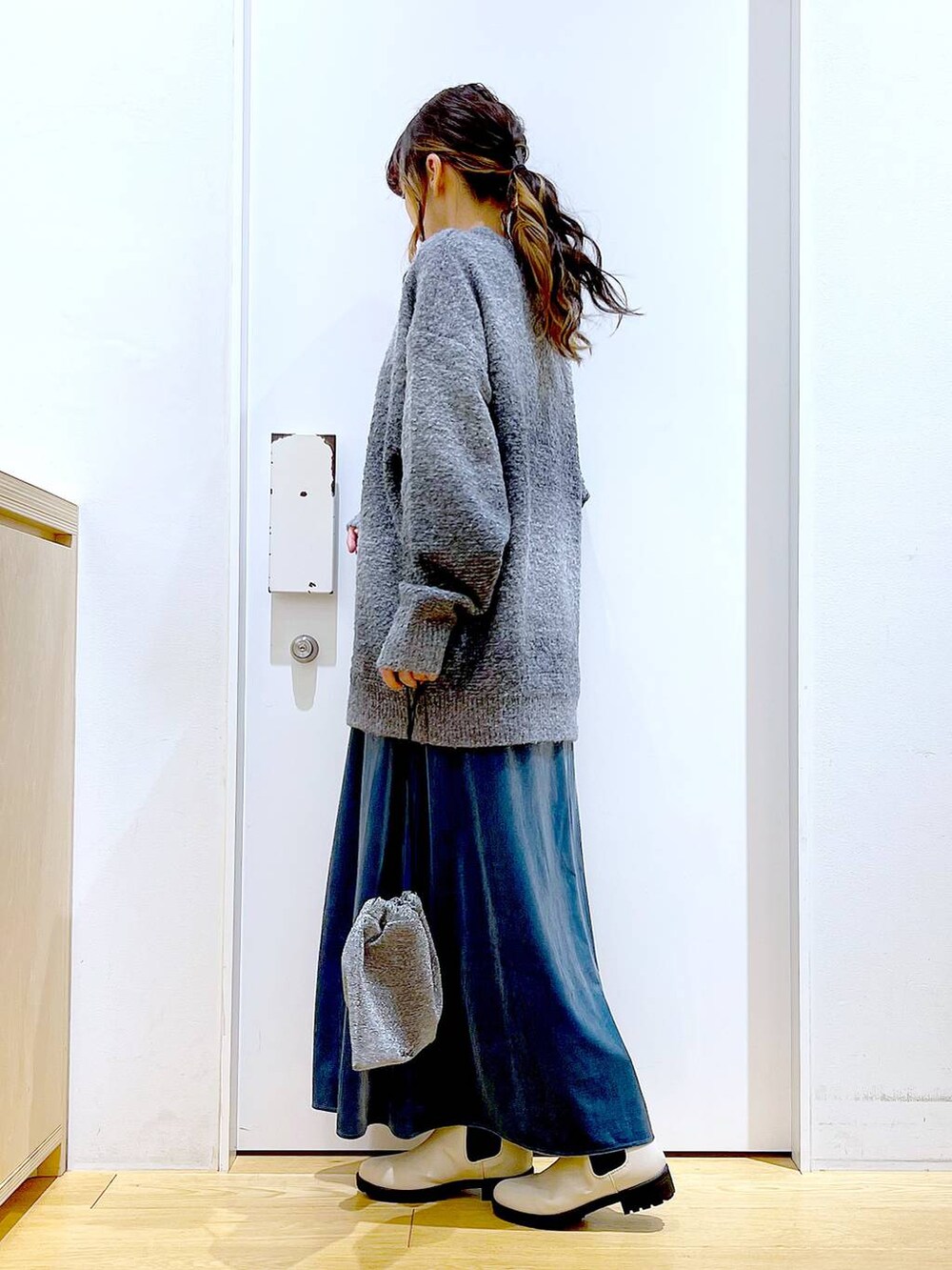 グレー系のニット/セーター、ベージュ系のブーツ、ブルー系のワンピースを着用したレディースの冬コーディネートの3枚目の写真