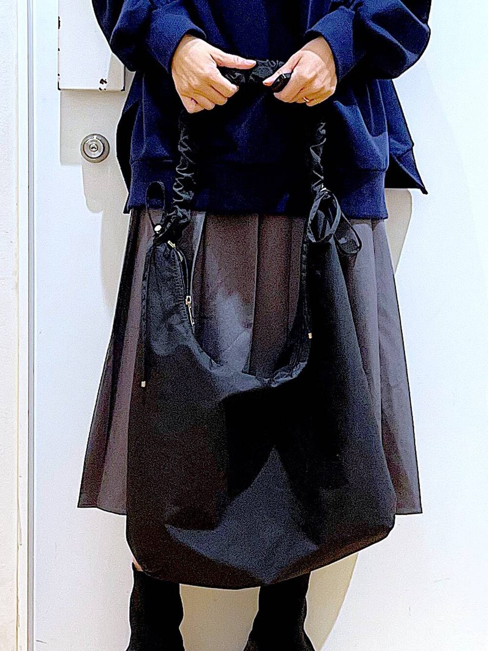 ブラック系のショルダーバッグ、ブラック系のブーツ、グレー系のスカートを着用したレディースの冬コーディネートの9枚目の写真