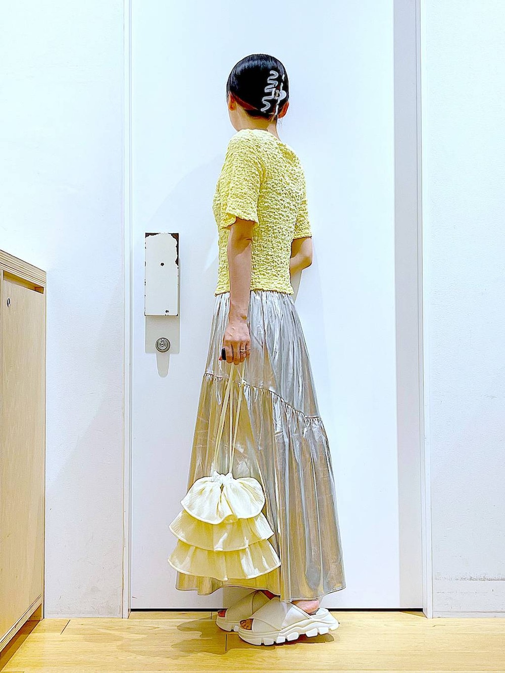 ホワイト系のサンダル、シルバー系のスカート、イエロー系のカーディガン/ボレロを着用したレディースの夏コーディネートの3枚目の写真