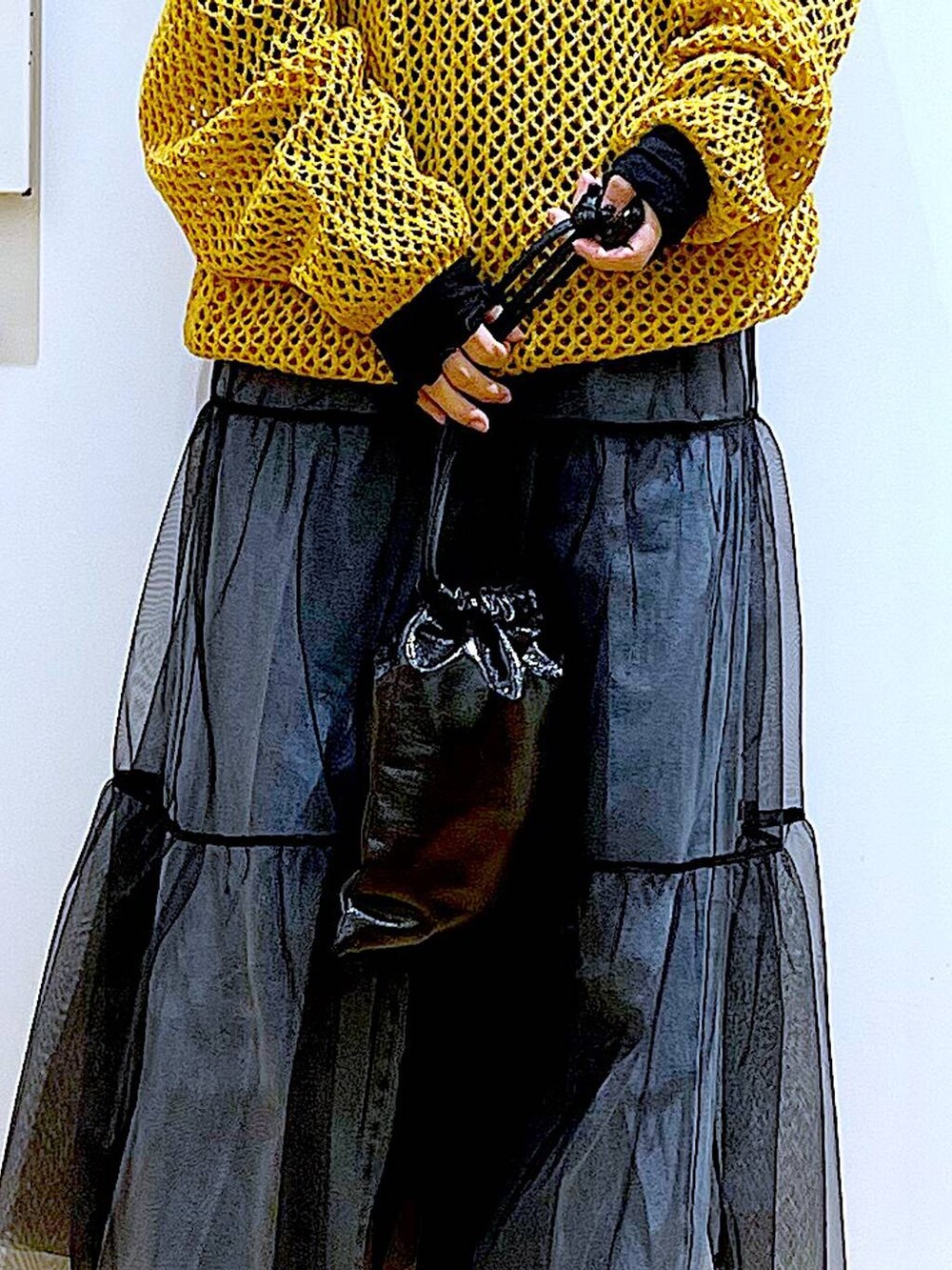 ブルー系のデニムパンツ、ブラック系のTシャツ/カットソー、オレンジ系のニット/セーターを着用したレディースの冬コーディネートの9枚目の写真