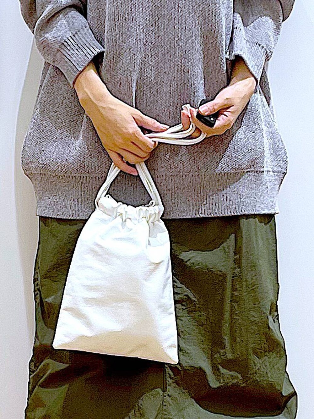 ブラック系のブーツ、グレー系のニット/セーター、グリーン系のスカートを着用したレディースの冬コーディネートの9枚目の写真