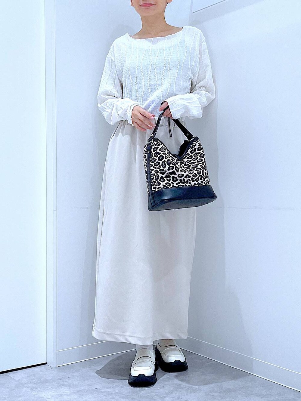 ベージュ系のスカート、ホワイト系のローファー、その他のショルダーバッグを着用したレディースの秋コーディネートの6枚目の写真