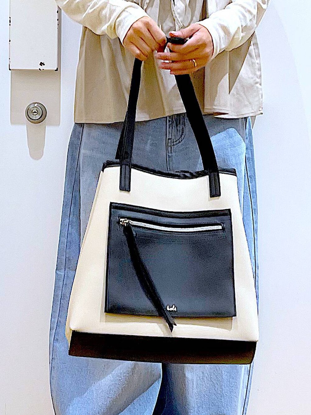 ブルー系のデニムパンツ、シルバー系のローファー、ホワイト系のトートバッグを着用したレディースの秋コーディネートの9枚目の写真