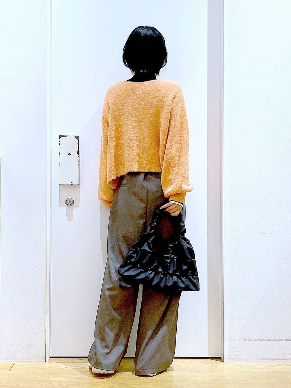 ブラック系のニット/セーター、ベージュ系のブーツ、ブラック系のショルダーバッグを着用したレディースの冬コーディネートの5枚目の写真