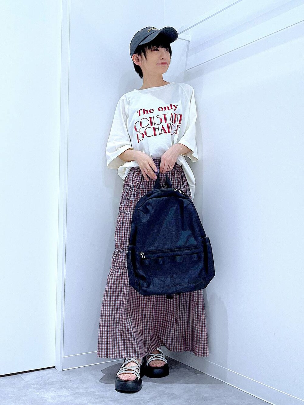 ブラック系のバックパック/リュック、シルバー系のサンダル、ホワイト系のTシャツ/カットソーを着用したレディースの夏コーディネートの2枚目の写真