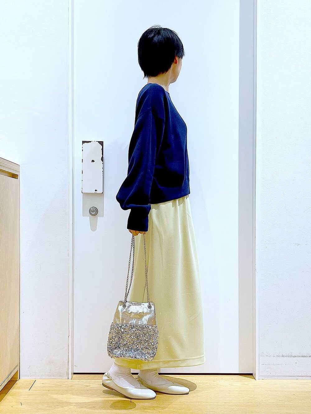 ホワイト系のパンプス、ブルー系のTシャツ/カットソー、イエロー系のスカートを着用したレディースの春コーディネートの4枚目の写真