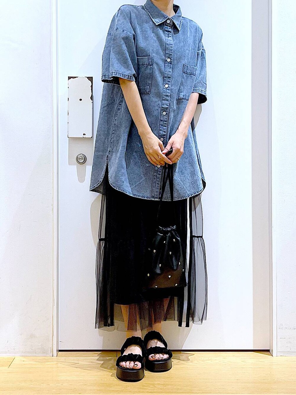 ブラック系のサンダル、ブラック系のショルダーバッグ、ブルー系のシャツ/ブラウスを着用したレディースの夏コーディネートの6枚目の写真