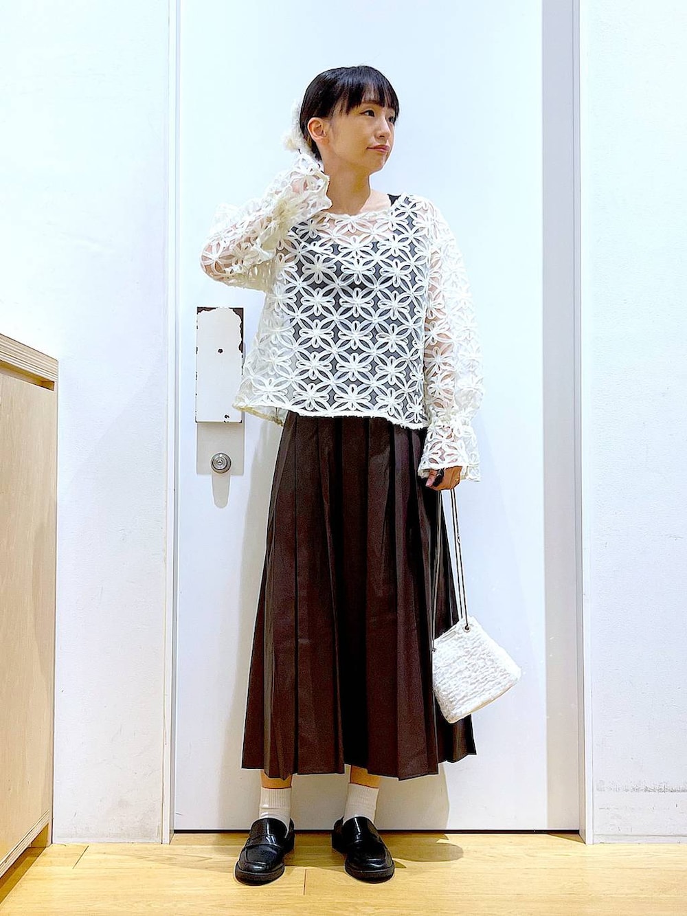 ホワイト系のショルダーバッグ、ブラック系のローファー、ベージュ系のシャツ/ブラウスを着用したレディースの秋コーディネートの2枚目の写真