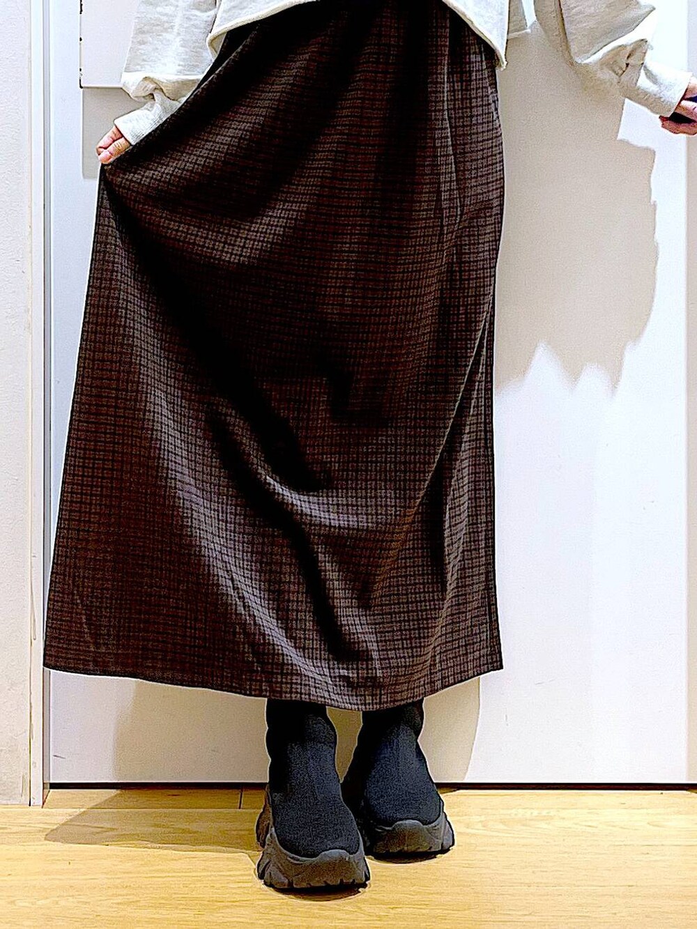 ブラック系のブーツ、ブラック系のショルダーバッグ、ブラウン系のワンピースを着用したレディースの冬コーディネートの8枚目の写真