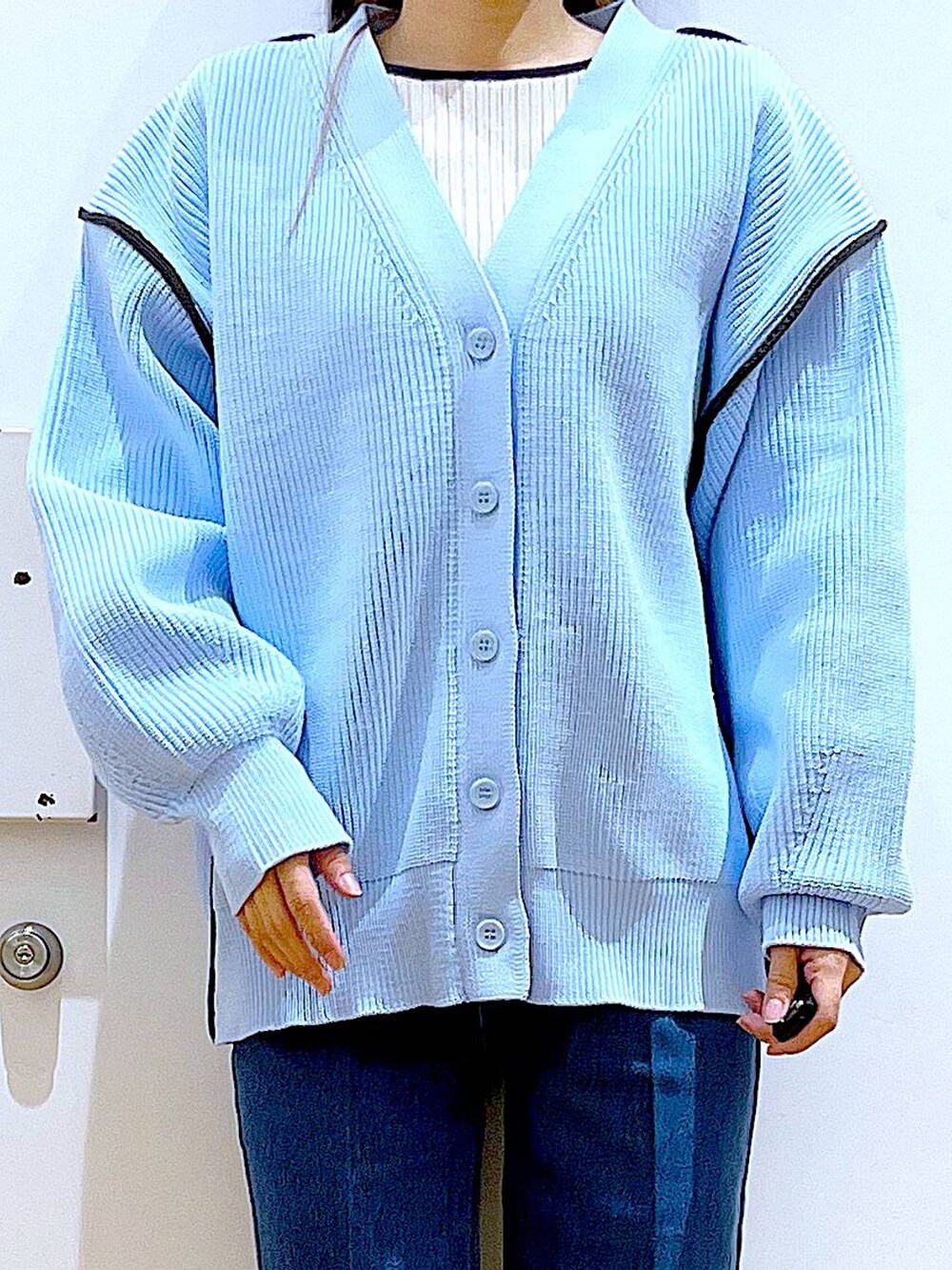 ブルー系のデニムパンツ、ベージュ系のブーツ、ベージュ系のニット/セーターを着用したレディースの冬コーディネートの7枚目の写真