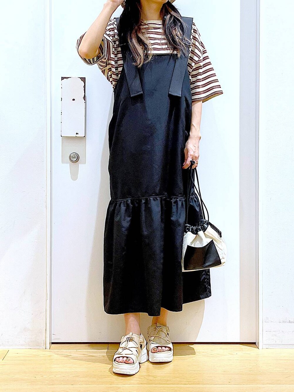 ホワイト系のショルダーバッグ、ブラック系のワンピース、ベージュ系のサンダルを着用したレディースの春コーディネートの6枚目の写真