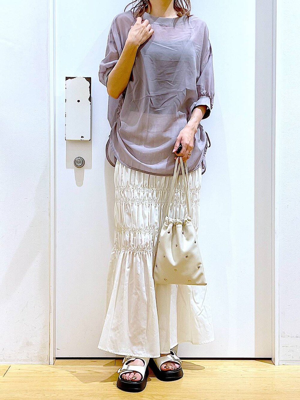 ホワイト系のサンダル、ホワイト系のショルダーバッグ、ホワイト系のスカートを着用したレディースの夏コーディネートの6枚目の写真
