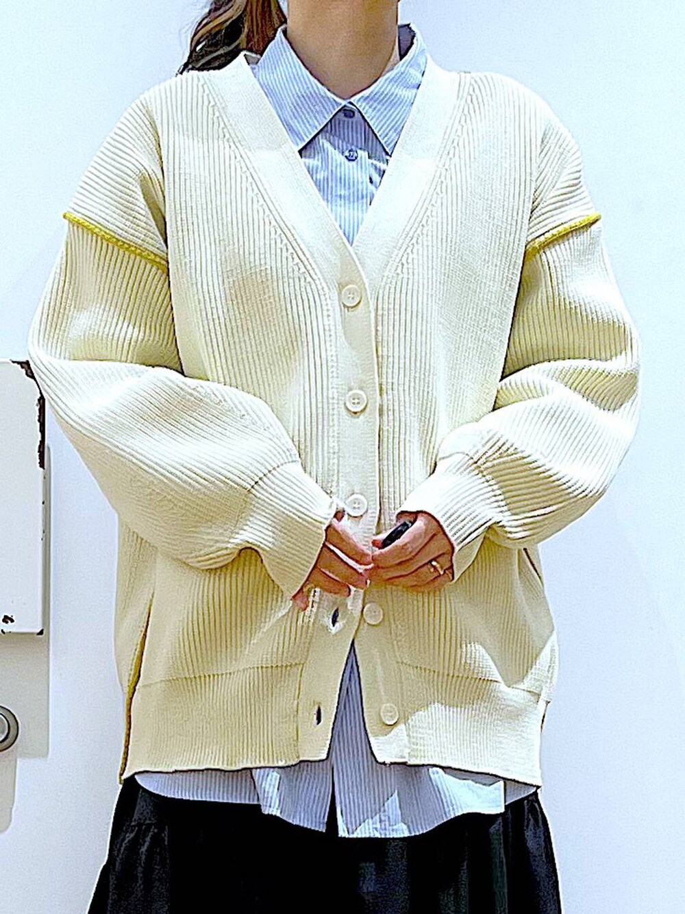 ホワイト系のショルダーバッグ、ホワイト系のカーディガン/ボレロ、ブラック系のスカートを着用したレディースの春コーディネートの7枚目の写真