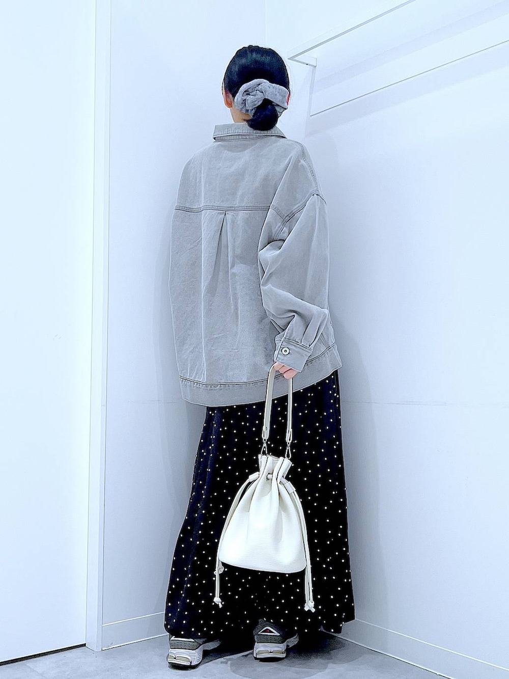 グレー系のデニムジャケット、ホワイト系のショルダーバッグ、グレー系のシュシュを着用したレディースの春コーディネートの5枚目の写真