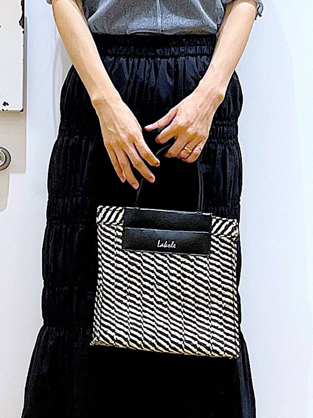 ブラック系のサンダル、ブラック系のショルダーバッグ、ブルー系のTシャツ/カットソーを着用したレディースの夏コーディネートの9枚目の写真