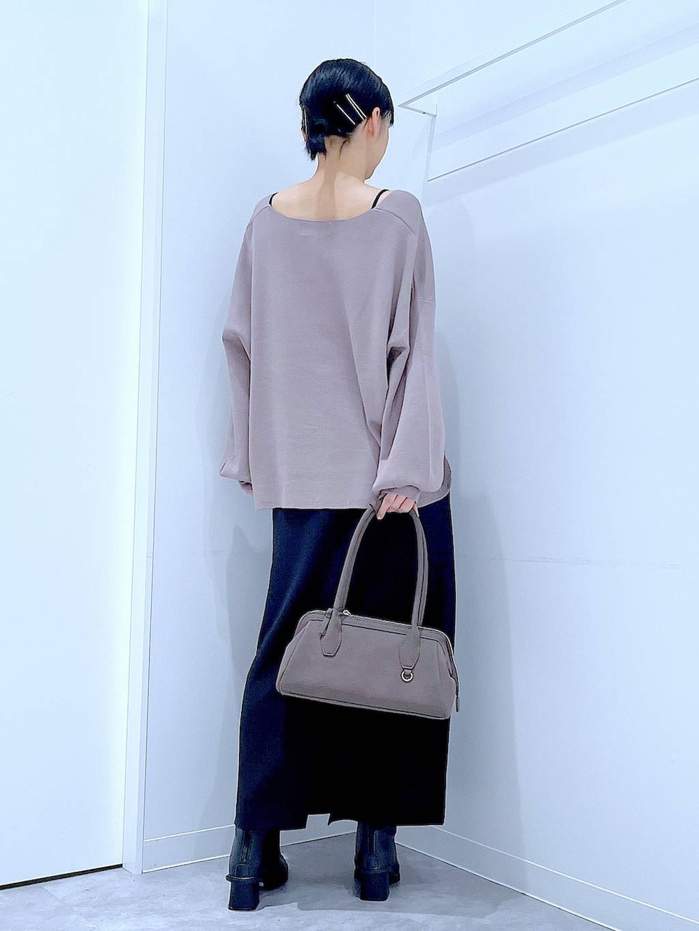 ブラック系のスカート、ブラウン系のニット/セーター、ブラック系のブーツを着用したレディースの秋コーディネートの5枚目の写真