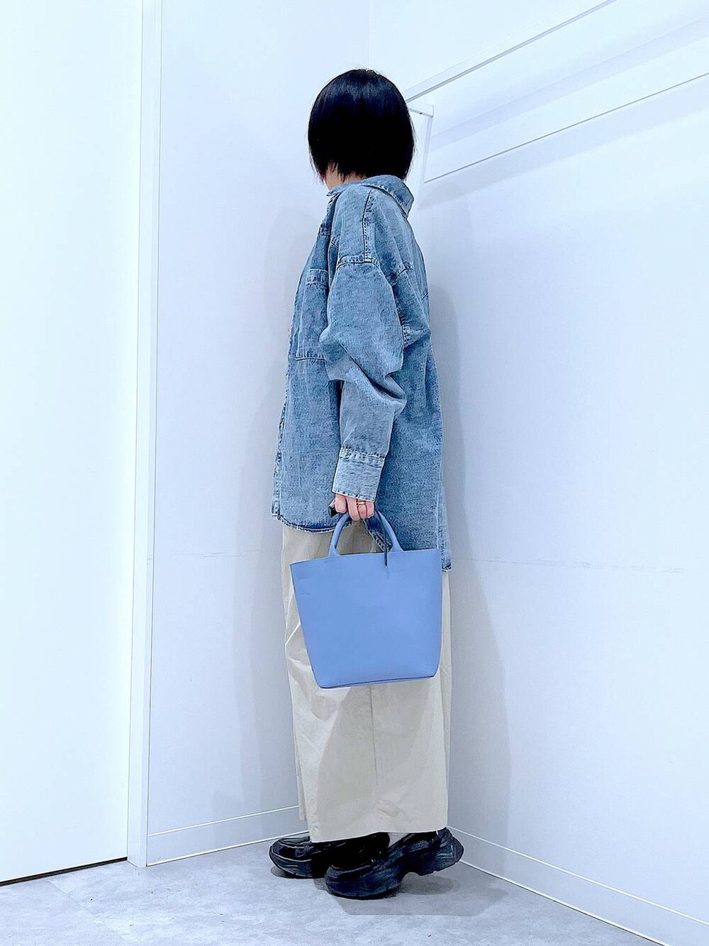 ブルー系のシャツ/ブラウス、ブルー系のショルダーバッグ、ブラック系のローファーを着用したレディースの秋コーディネートの3枚目の写真