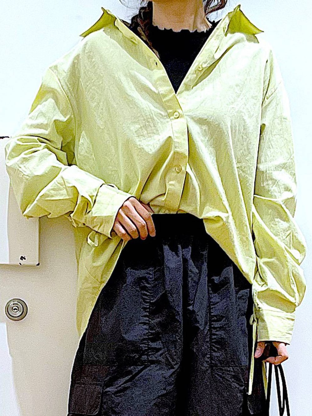 グリーン系のシャツ/ブラウス、ブラック系のショルダーバッグ、ブラック系のパンプスを着用したレディースの春コーディネートの7枚目の写真