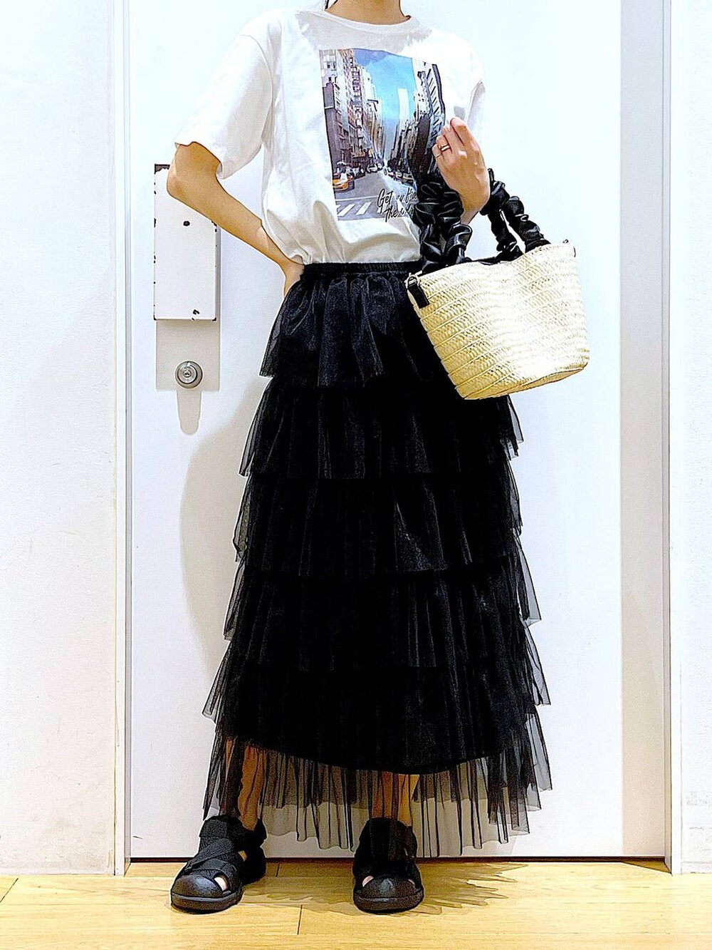 ホワイト系のショルダーバッグ、ブラック系のスリッポン、ブラック系のスカートを着用したレディースの夏コーディネートの6枚目の写真