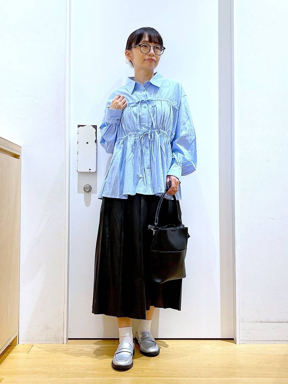 シルバー系のローファー、ブラック系のショルダーバッグ、ブルー系のシャツ/ブラウスを着用したレディースの秋コーディネートの2枚目の写真