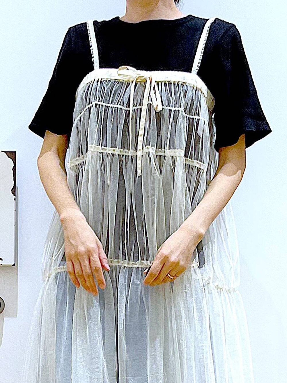 ブルー系のデニムパンツ、ホワイト系のショルダーバッグ、ブラック系のTシャツ/カットソーを着用したレディースの夏コーディネートの7枚目の写真