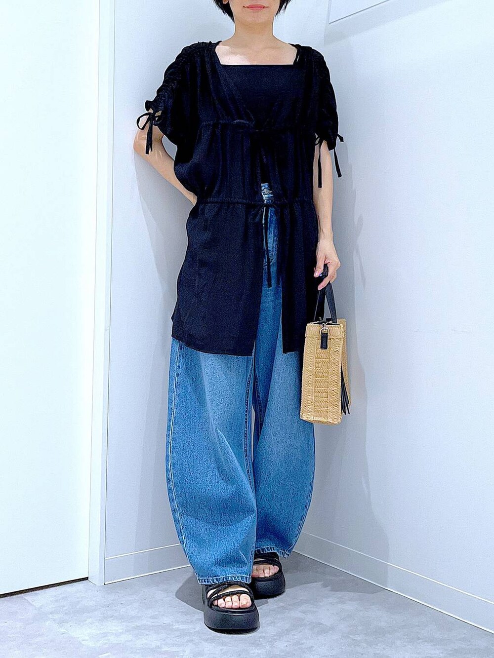 ブルー系のデニムパンツ、ベージュ系のショルダーバッグ、ブラック系のサンダルを着用したレディースの夏コーディネートの6枚目の写真