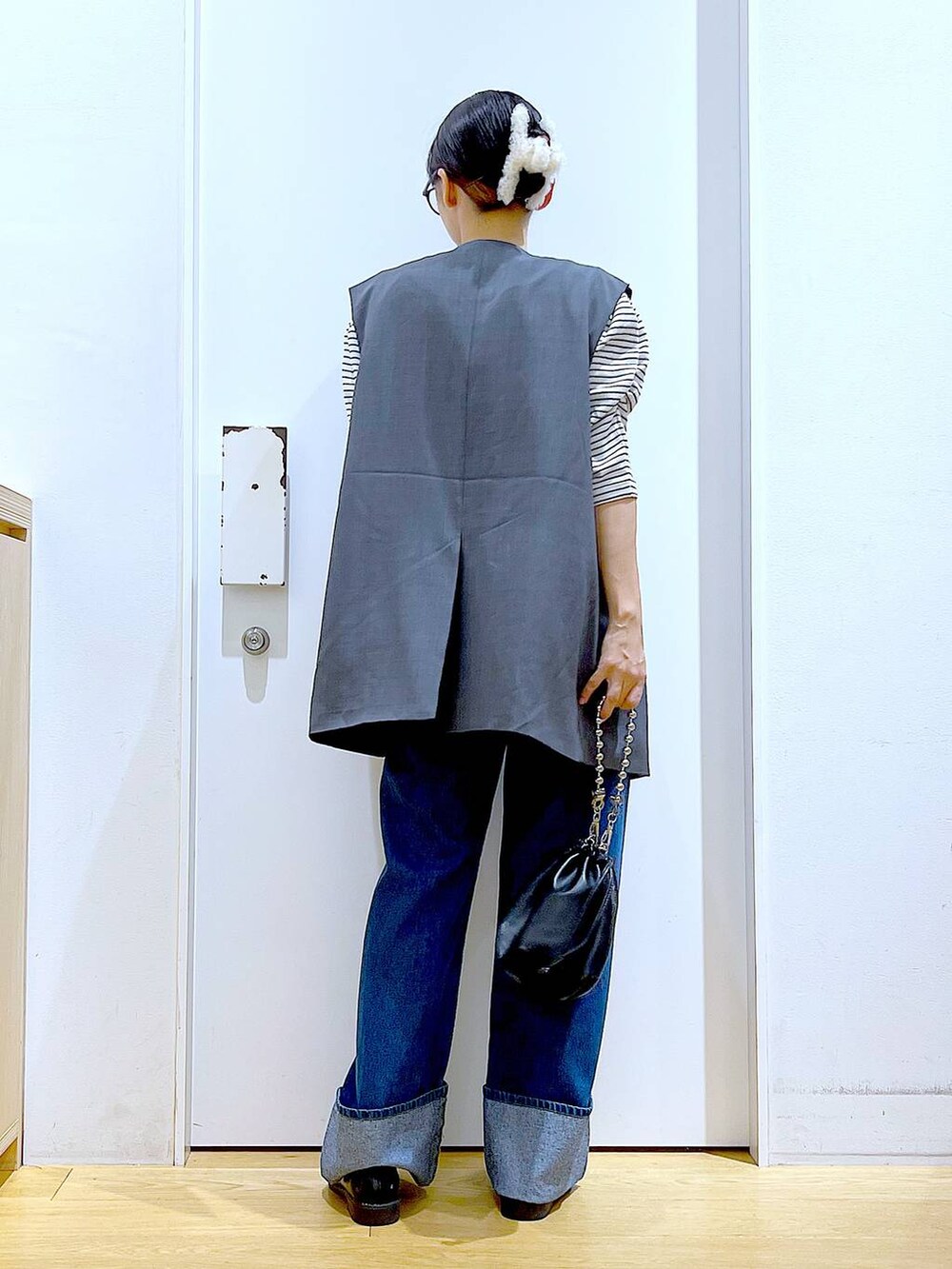 ブラック系のショルダーバッグ、ブラック系のローファー、グレー系のベストを着用したレディースの秋コーディネートの5枚目の写真