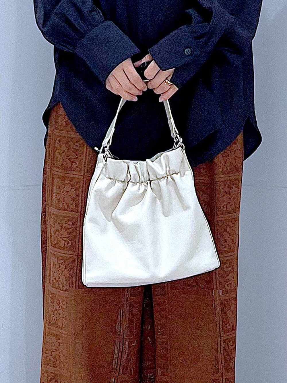 ブラック系のシャツ/ブラウス、ホワイト系のショルダーバッグ、ホワイト系のスニーカーを着用したレディースの春コーディネートの9枚目の写真