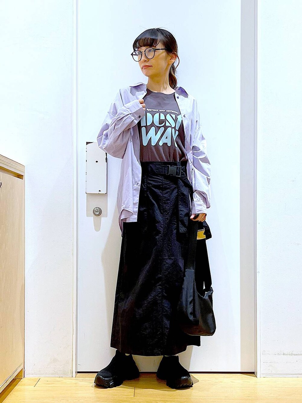 ブルー系のシャツ/ブラウス、ブラック系のスニーカー、ブラック系のショルダーバッグを着用したレディースの春コーディネートの2枚目の写真