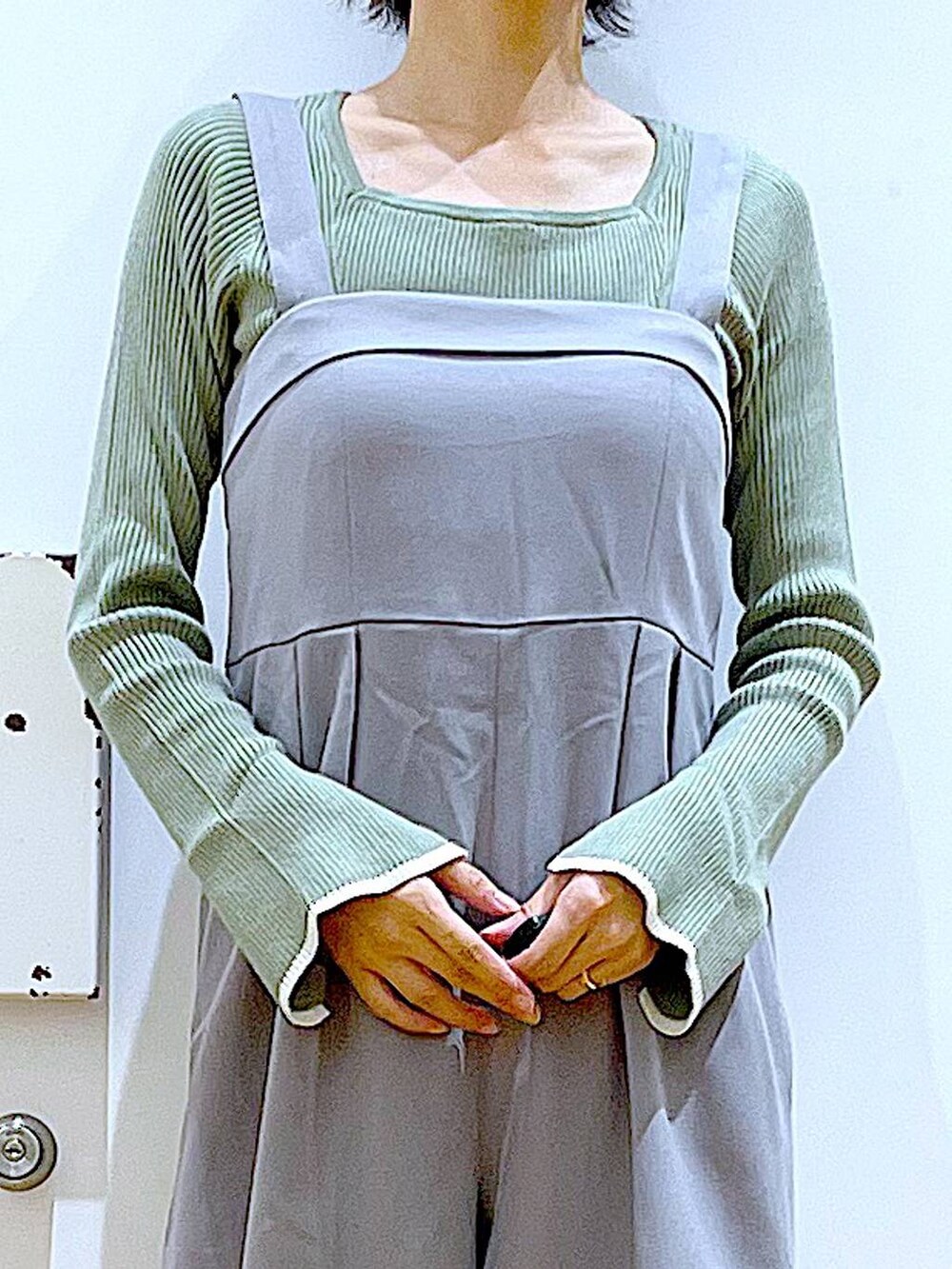 グリーン系のニット/セーター、グレー系のサロペット/オーバーオール、グレー系のショルダーバッグを着用したレディースの秋コーディネートの7枚目の写真