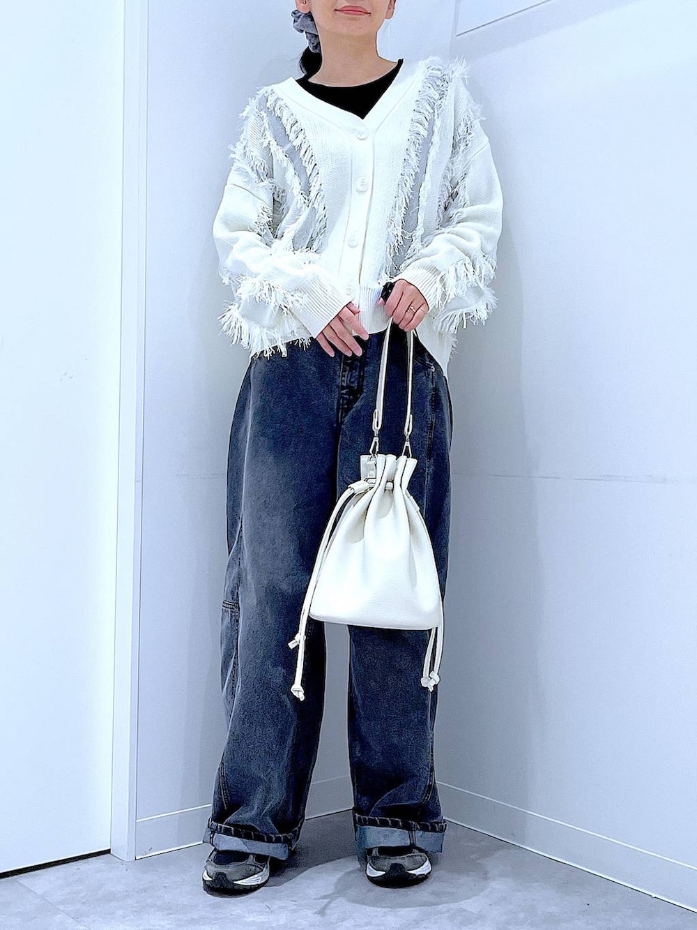 ブラック系のTシャツ/カットソー、ブラック系のデニムパンツ、ホワイト系のショルダーバッグを着用したレディースの春コーディネートの6枚目の写真