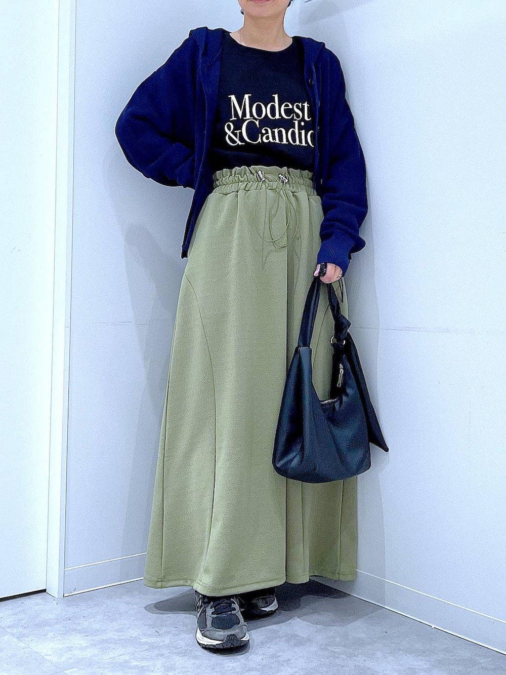 ブラック系のTシャツ/カットソー、ブラック系のショルダーバッグ、グリーン系のスカートを着用したレディースの春コーディネートの6枚目の写真