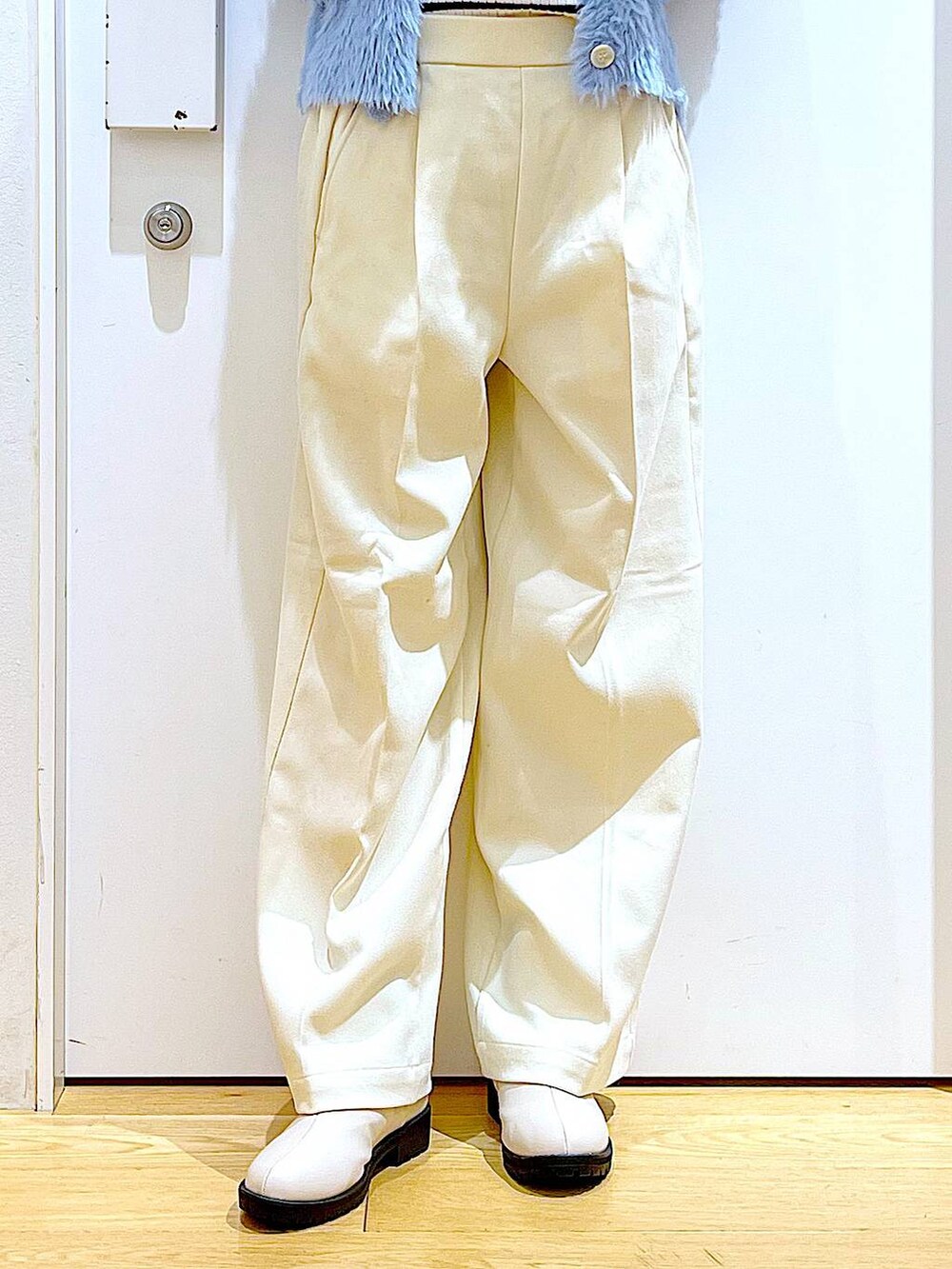 シルバー系のショルダーバッグ、ベージュ系のブーツ、ホワイト系のニット/セーターを着用したレディースの冬コーディネートの8枚目の写真